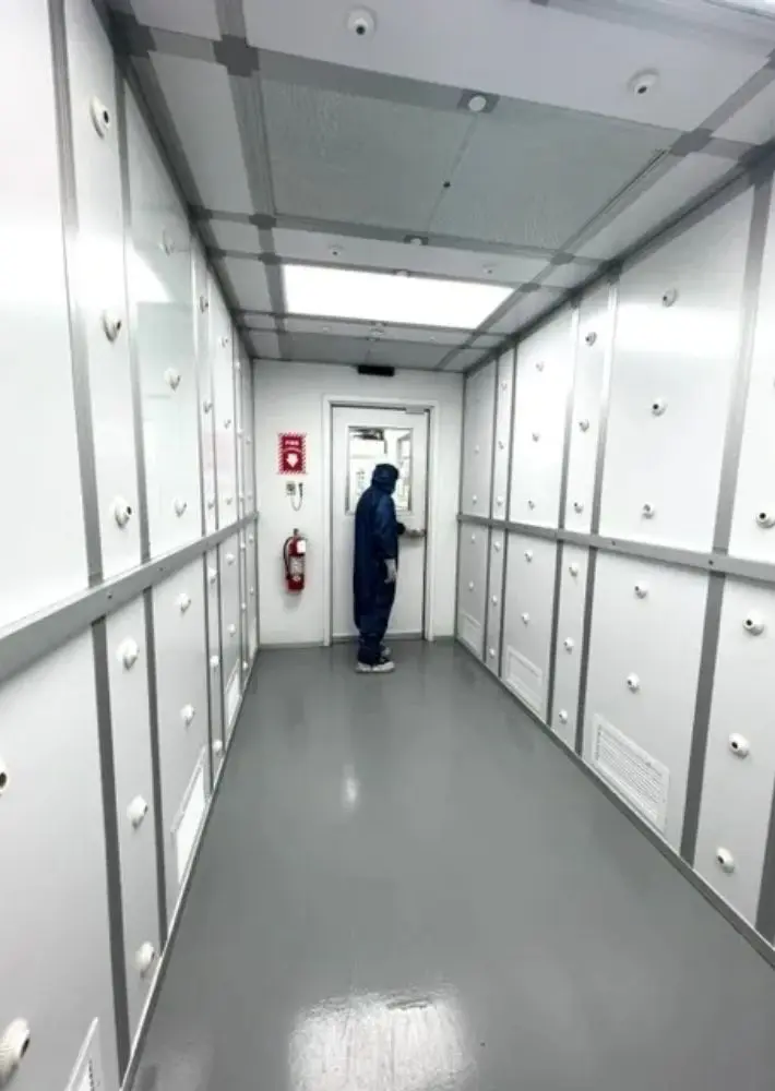 A person in a hallway with many cabinets